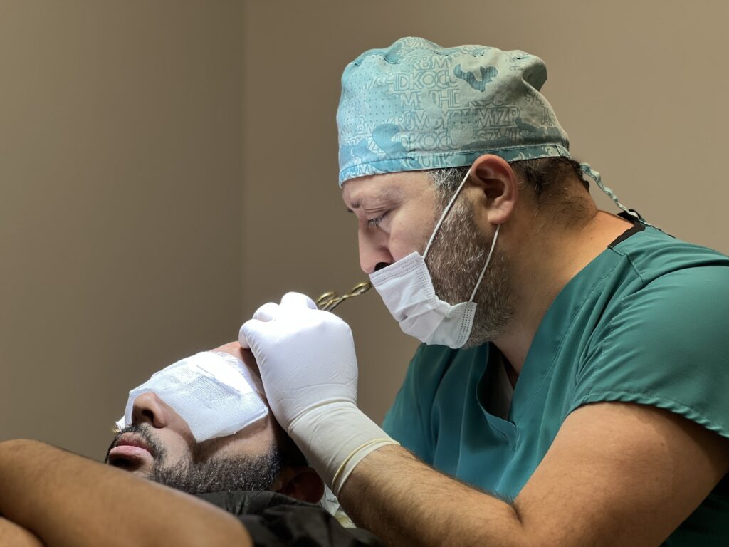 Dr Alp Aslan performing a hair transplant surgery with a natural hairline design